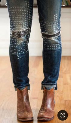 the legs and ankles of a person wearing jeans with studded knee patches on them