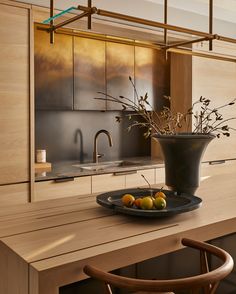 a bowl of fruit is on the kitchen counter