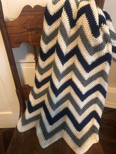 a crocheted blanket sitting on top of a wooden chair