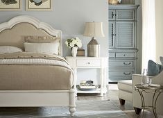 a bedroom with blue walls and white furniture