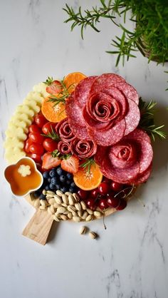 a platter filled with meat, fruit and veggies