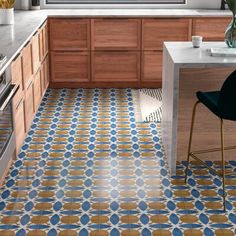 a kitchen with blue and yellow tiles on the floor