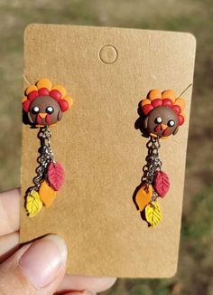 a pair of earrings that have been made to look like turkeys with feathers on them