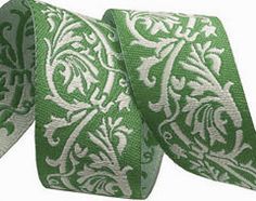 a green and white tie with an ornate design on it's side, in front of a white background