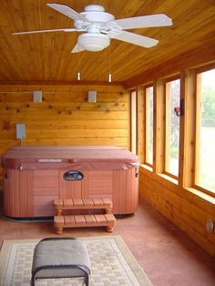 a large hot tub sitting inside of a wooden room