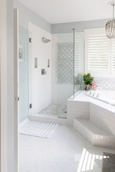 a large white bathroom with a walk in shower