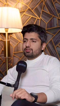 a man sitting in front of a microphone