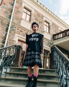 a man in a kilt is standing on the steps with his hand up to his face