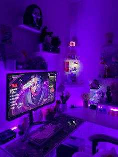 a computer monitor sitting on top of a desk next to a keyboard and mouse in front of a purple lit room