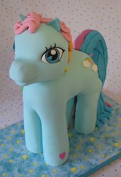 there is a small toy pony on top of a table with blue and pink decorations