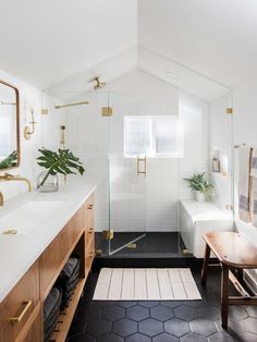 a bathroom with black and white tile flooring and wooden cabinetry, along with an open shower