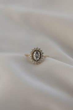 a diamond ring sitting on top of a white cloth