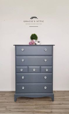 a blue dresser with drawers in front of a white wall