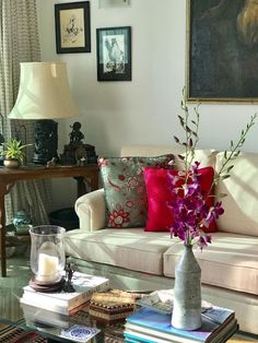 a living room filled with lots of furniture and flowers on top of a coffee table