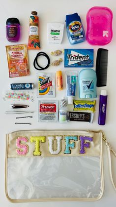 the contents of a purse laid out on top of a white table with zippered pouch