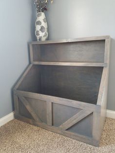 a wooden bed frame sitting on top of a carpeted floor next to a vase