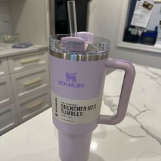 a purple tumbler cup sitting on top of a counter