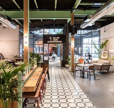 the interior of a restaurant with tables, chairs and potted plants