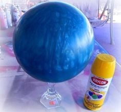 a blue ball sitting on top of a table next to a can of paint and glue