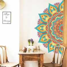 a room with two chairs and a table in front of a large colorful wall mural