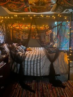 a bedroom decorated in halloween colors with lights strung from the ceiling and decorations on the bed