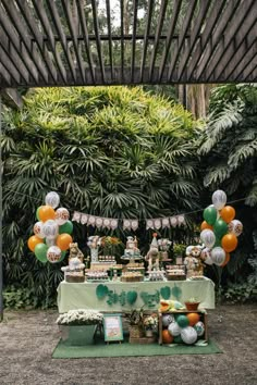 an outdoor party with balloons, cake and desserts on the table for st patrick's day