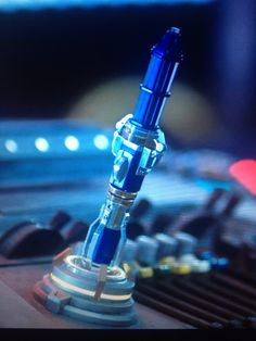 a blue fountain pen sitting on top of a metal object in front of a keyboard