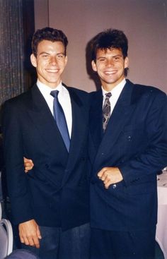 two men in suits standing next to each other