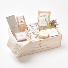 a wooden box filled with lots of different types of personal care items on top of a white surface