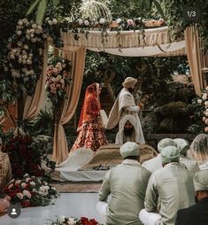 the bride and groom are getting married in front of an altar with flowers on it