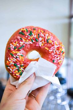 a person holding up a donut with sprinkles on it and the words, 5 best doughnuts in phoenix