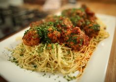 spaghetti and meatballs on a white plate