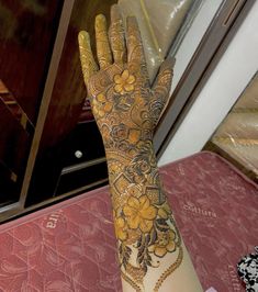 a woman's hand with henna on it and flowers painted on the palm