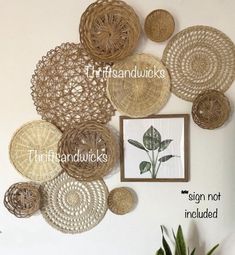 the wall is decorated with wicker baskets and pictures on it, along with a potted plant