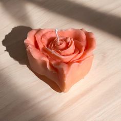 a rose shaped soap bar sitting on top of a wooden table