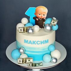 a birthday cake decorated with money and an image of a baby in a suit on top