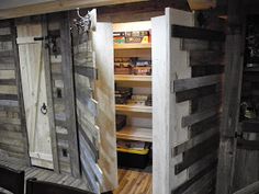 an open door to a storage room with wooden shelves and doors on both sides, in the middle of a wood floor