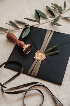 an envelope with a wax stamp and ribbon tied around it, sitting on a table