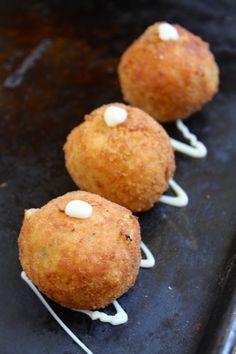 three fried food items sitting on top of a pan