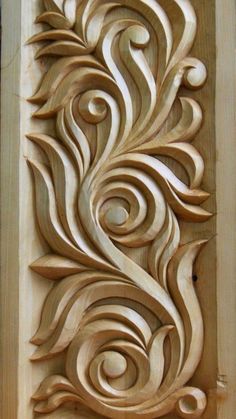 an intricate carved wood panel with swirls on it