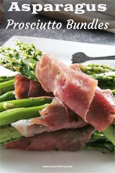 asparagus wrapped in prosciutto on a white plate