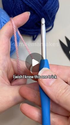 someone is knitting yarn with blue crochet hooks