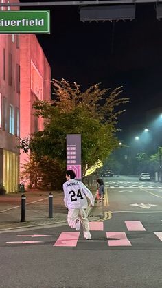 a person crossing the street at night