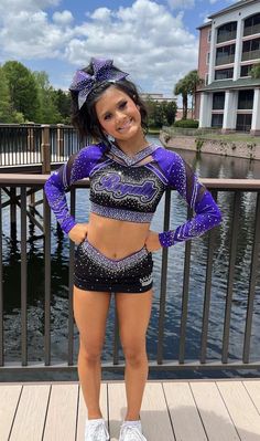 a woman in a purple and black outfit standing on a dock