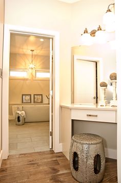 an open door leading to a bathroom with a vanity and stool in the middle of it