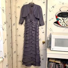 a dress hanging on the wall next to a microwave