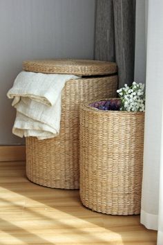 two wicker baskets sitting next to each other on top of a hard wood floor