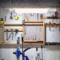 a workbench with many tools hanging on the wall