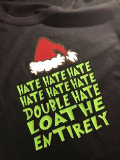 a santa hat on top of a black shirt with green lettering that says hate hate hate hate