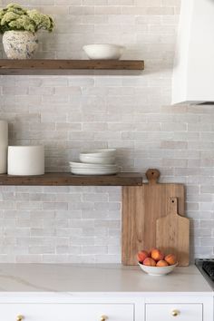 a kitchen with white brick walls and open shelving above the countertop is filled with fruit